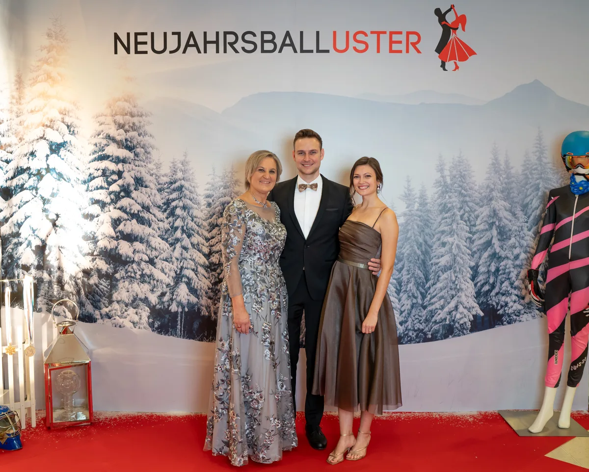 Gruppenbild mit einem Mann und zwei Frauen. Sie tragen festliche Kleidung.